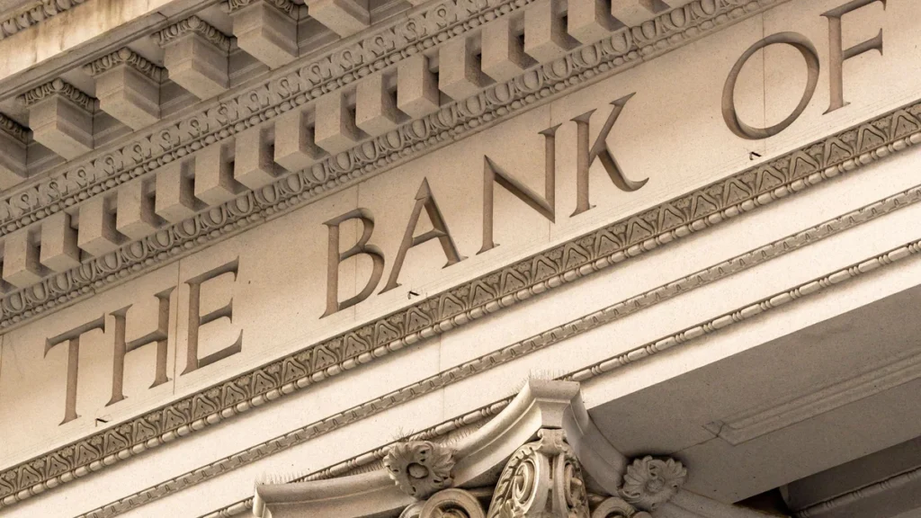 Stone bank building facade with classical columns and carved bank lettering.