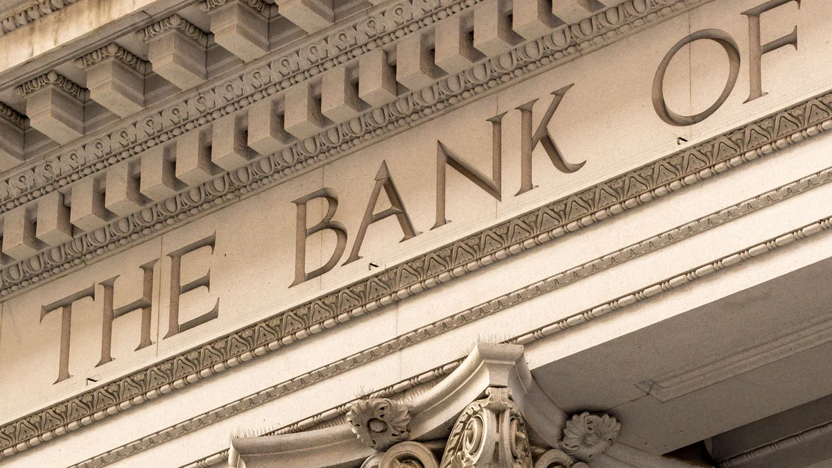 Stone bank building facade with classical columns and carved bank lettering.
