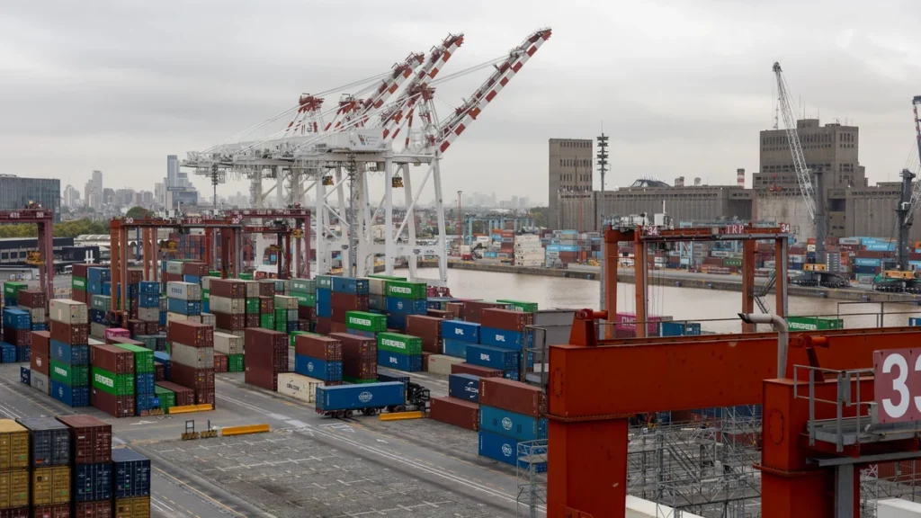 Aerial view of cranes and stacked shipping containers at a port in Buenos Aires.