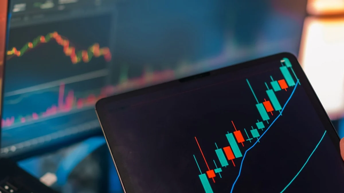 Tablet and laptop displaying stock market charts used for trading analysis.