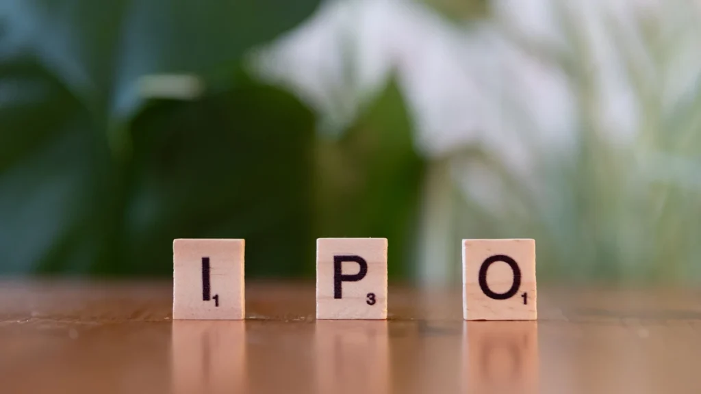 Wooden letter blocks spelling IPO on a table.