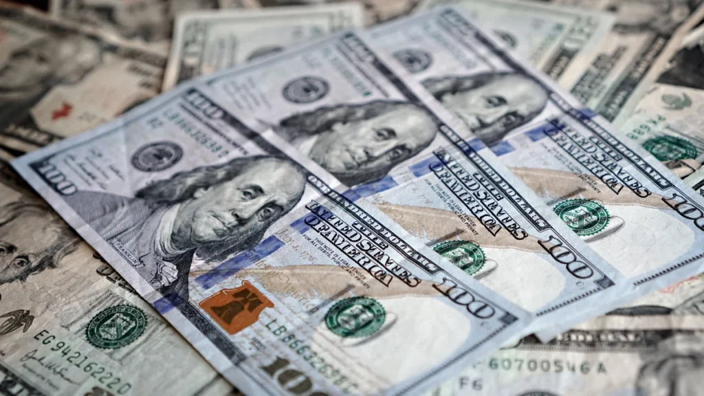 Stack of U.S. dollar bills arranged on a surface.
