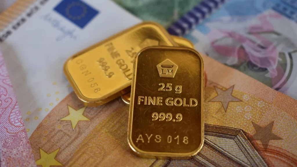 Two gold bullion bars resting on euro banknotes.