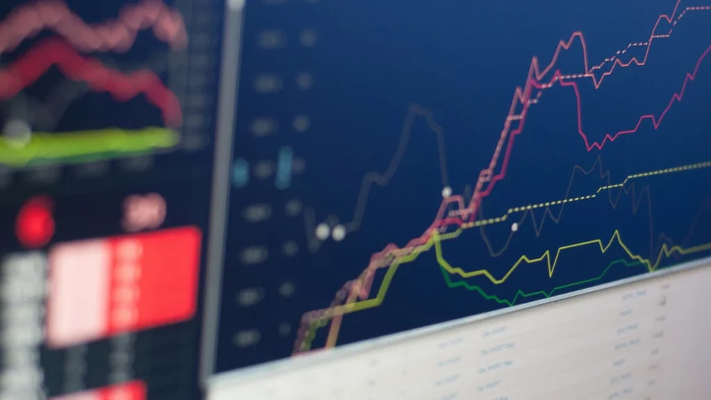 Close-up of financial market charts displayed on computer monitors.