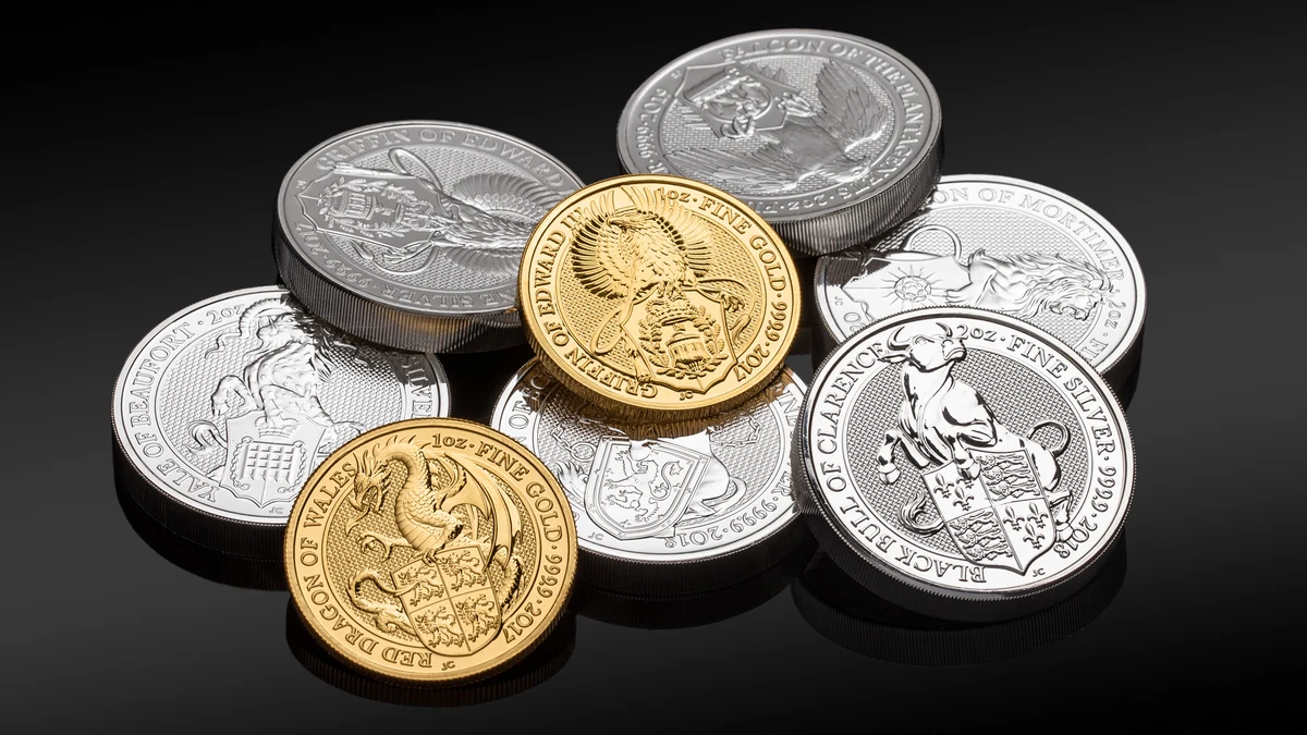 Gold and silver bullion coins arranged on a black surface.