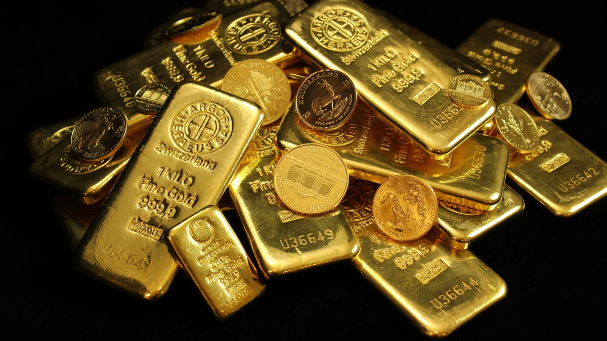 Gold bars and gold coins arranged on a black background.