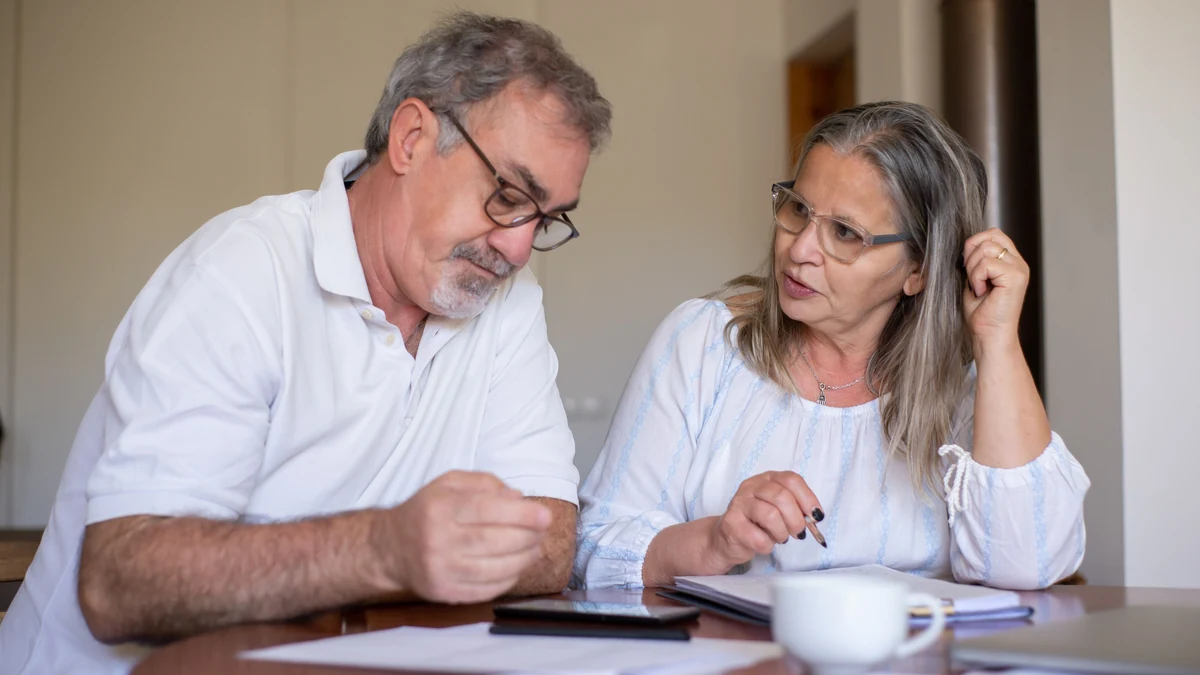 Older couple reviewing financial documents together at a table.