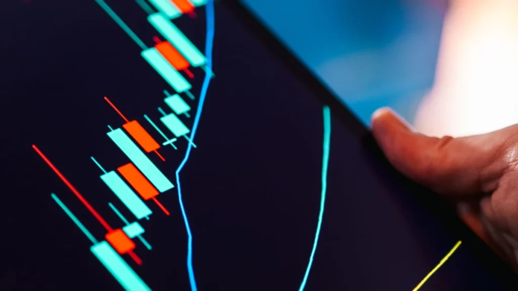 Close-up of a tablet displaying red and green candlestick price charts.