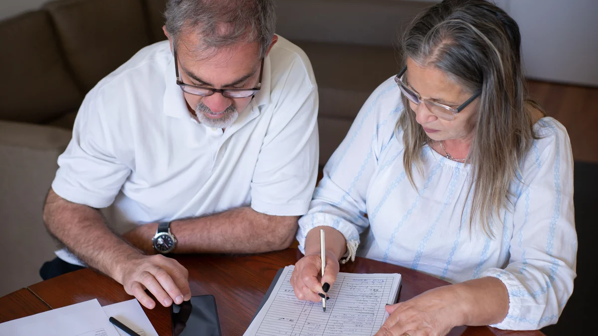 Older couple reviewing financial documents together at a table.