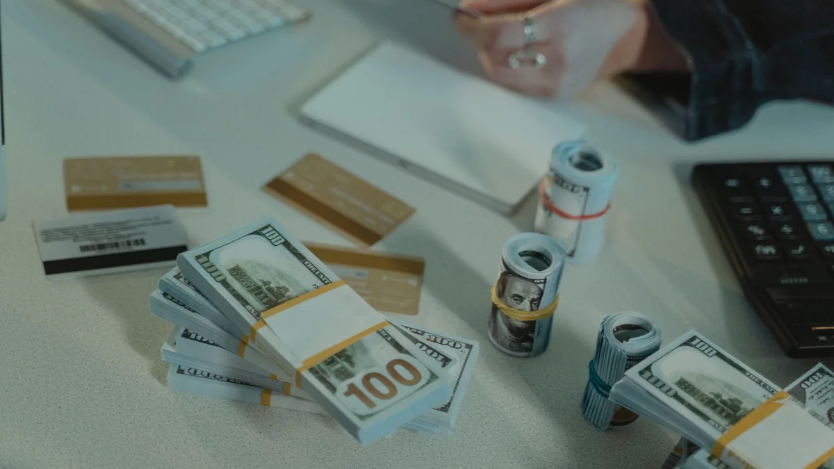 Credit cards and cash arranged on a desk beside a calculator during financial planning.