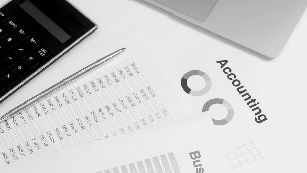 A laptop, calculator and printed financial statements arranged on a desk.