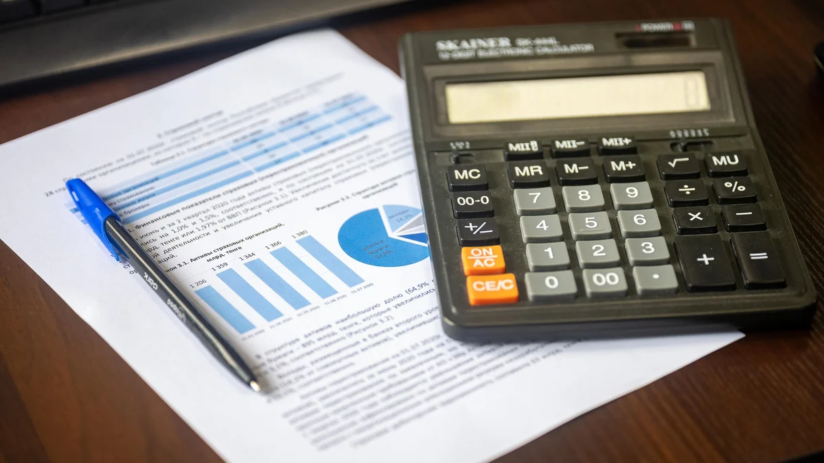 Calculator and printed financial charts on a desk.