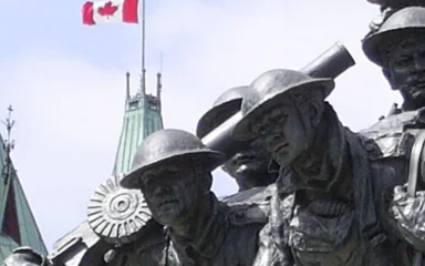 National War Memorial sculpture with the Peace Tower on Parliament Hill in Ottawa.