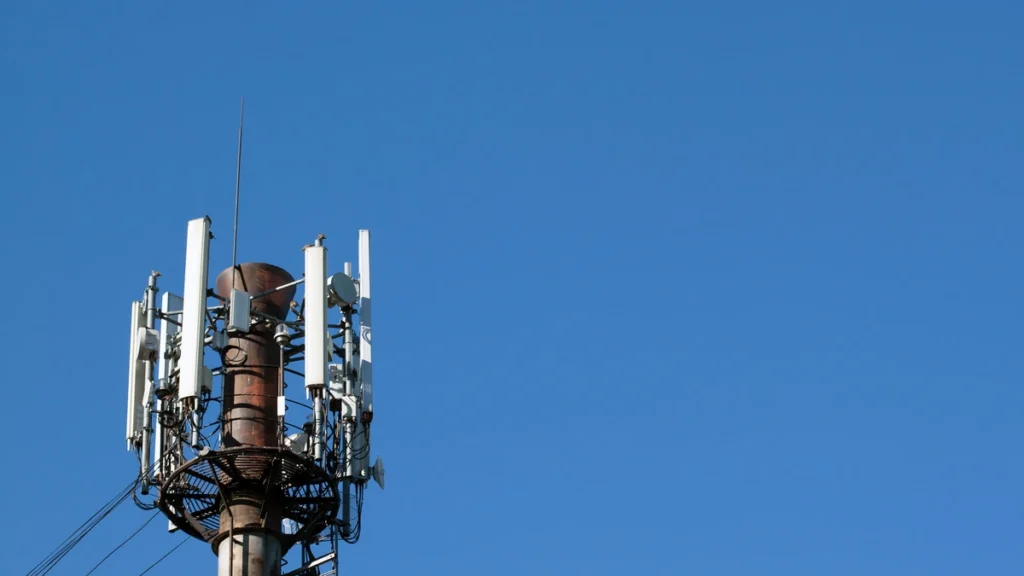 Cellular communications tower fitted with antennas and electronic communications equipment.