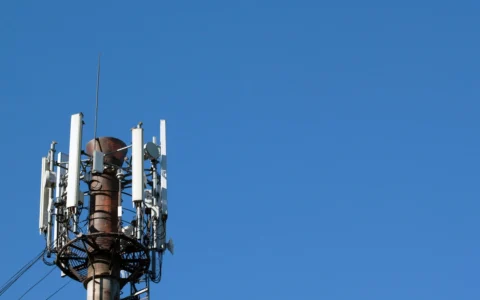 Cellular communications tower fitted with antennas and electronic communications equipment.