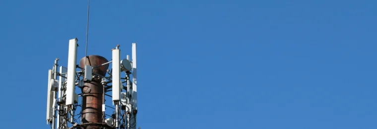 Cellular communications tower fitted with antennas and electronic communications equipment.