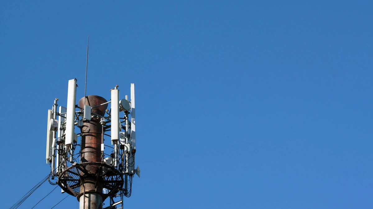 Cellular communications tower fitted with antennas and electronic communications equipment.