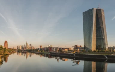 European Central Bank headquarters beside the Frankfurt skyline at dawn.