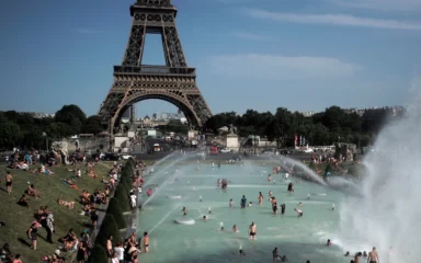 People cooling off in fountains near the Eiffel Tower in Paris during a heatwave.
