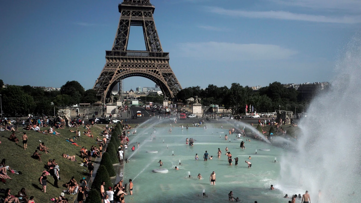 People cooling off in fountains near the Eiffel Tower in Paris during a heatwave.