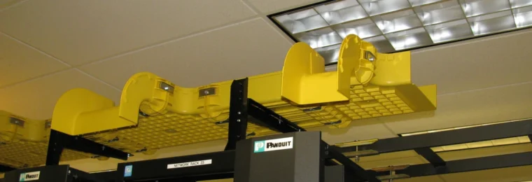 Yellow fiber-optic cable management trays above networking racks.