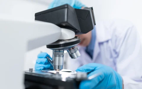 Scientist using a microscope in a laboratory.