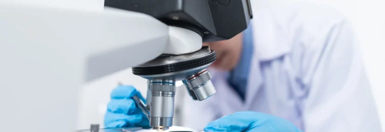 Scientist using a microscope in a laboratory.