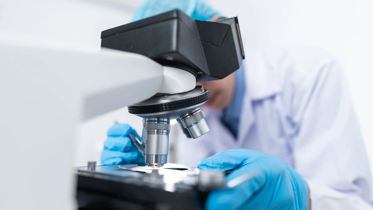 Scientist using a microscope in a laboratory.