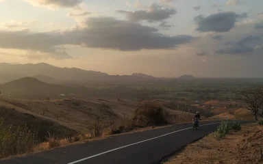 Hilly terrain and a paved road in Nagekeo Regency on Flores, Indonesia.