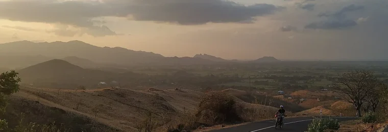 Hilly terrain and a paved road in Nagekeo Regency on Flores, Indonesia.
