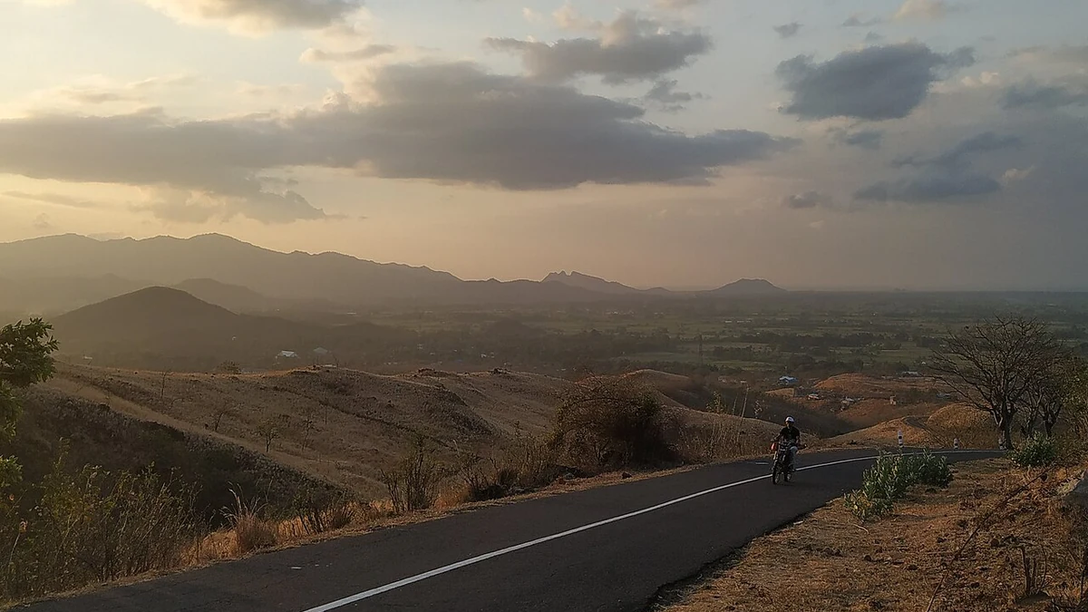 Hilly terrain and a paved road in Nagekeo Regency on Flores, Indonesia.