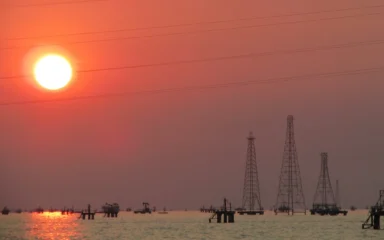 Oil drilling rigs on Lake Maracaibo near Lagunillas, Venezuela, at sunset.