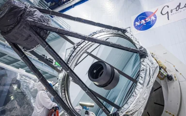 Optical engineer Bente Eegholm inspects the 2.4-meter primary mirror for NASA’s Nancy Grace Roman Space Telescope.