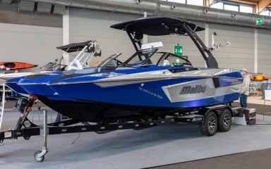 Blue Malibu wake boat displayed indoors at the Interboot 2020 boat show in Friedrichshafen, Germany.