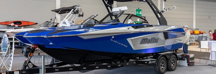 Blue Malibu wake boat displayed indoors at the Interboot 2020 boat show in Friedrichshafen, Germany.