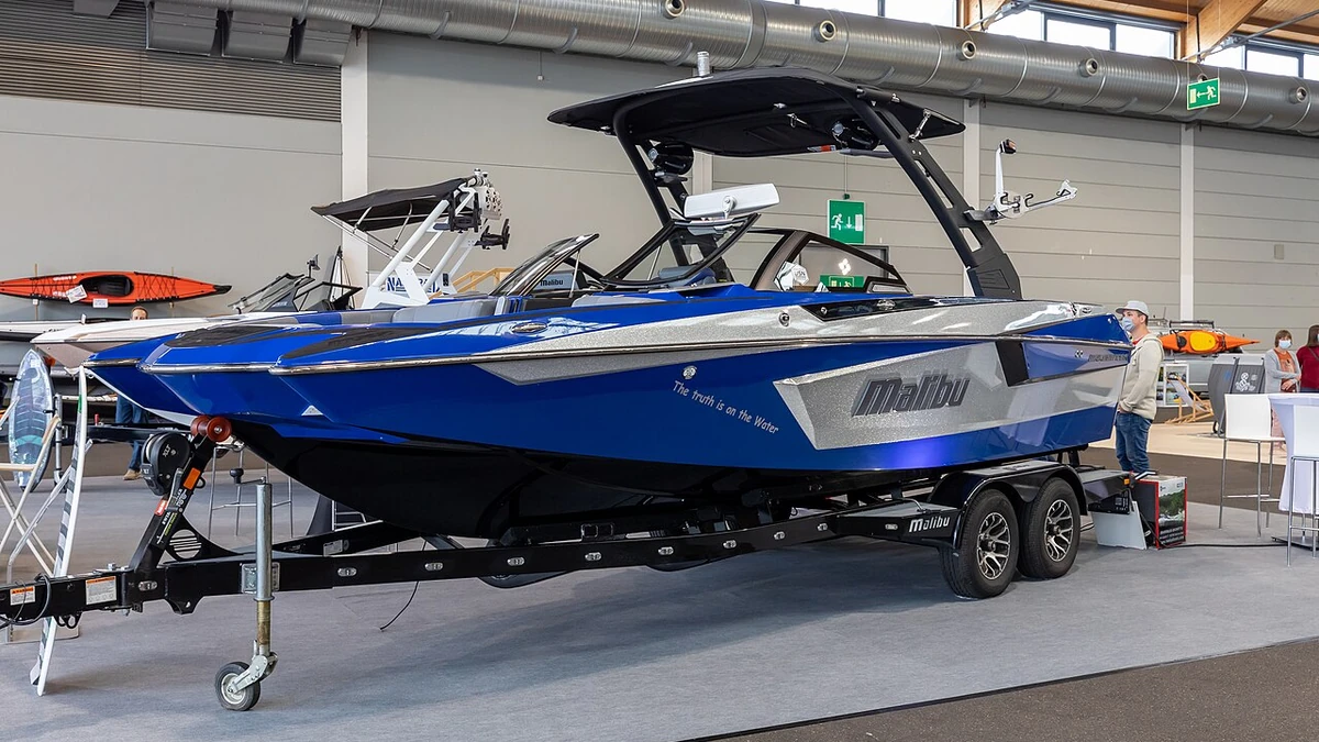 Blue Malibu wake boat displayed indoors at the Interboot 2020 boat show in Friedrichshafen, Germany.