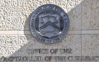 Office of the Comptroller of the Currency seal and name displayed outside its Washington headquarters.