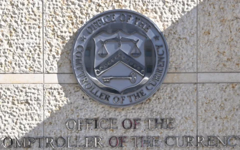 Office of the Comptroller of the Currency seal and name displayed outside its Washington headquarters.