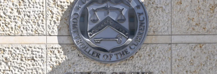 Office of the Comptroller of the Currency seal and name displayed outside its Washington headquarters.