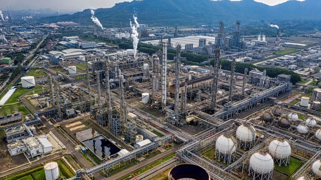 Aerial view of an oil refinery with processing units, pipelines and storage tanks in Banten, Indonesia.