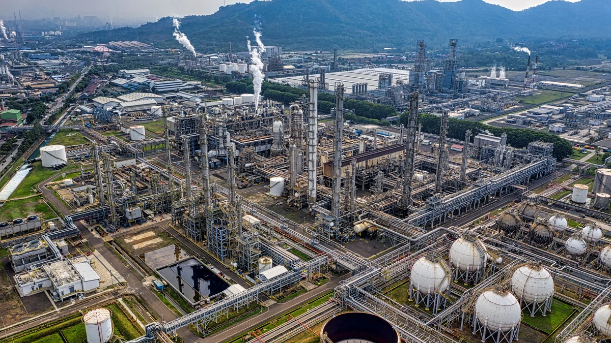 Aerial view of an oil refinery with processing units, pipelines and storage tanks in Banten, Indonesia.