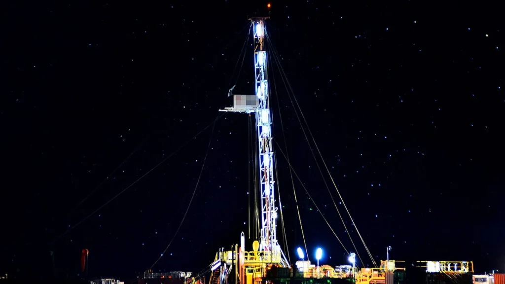 Oil drilling rig illuminated at night in Añelo, Neuquén Province, Argentina.