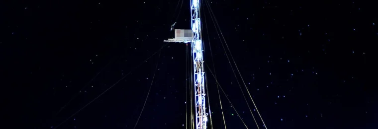 Oil drilling rig illuminated at night in Añelo, Neuquén Province, Argentina.