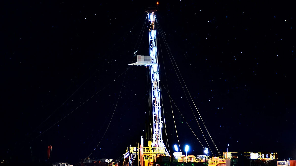 Oil drilling rig illuminated at night in Añelo, Neuquén Province, Argentina.