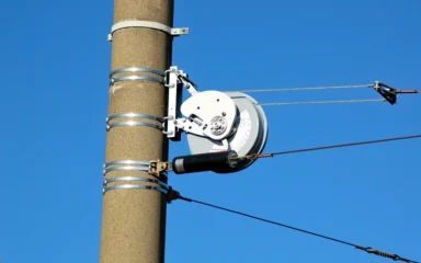 PFISTERER-branded overhead wire tensioner mounted on a utility pole.