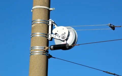 PFISTERER-branded overhead wire tensioner mounted on a utility pole.