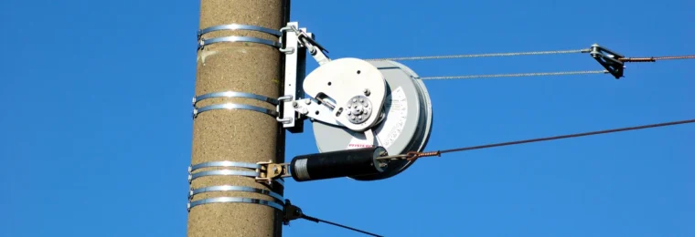 PFISTERER-branded overhead wire tensioner mounted on a utility pole.