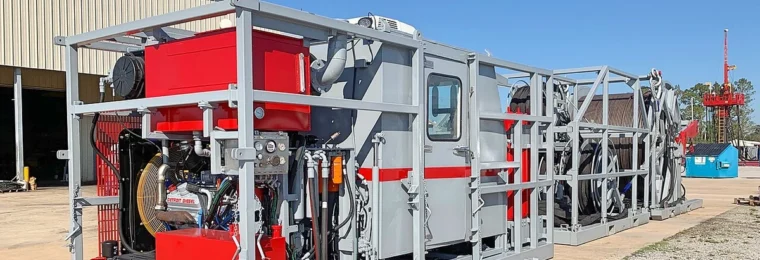 Skid-mounted coiled tubing unit at an industrial site.