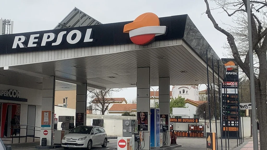 Repsol petrol station in Spain with fuel prices displayed on a roadside board.