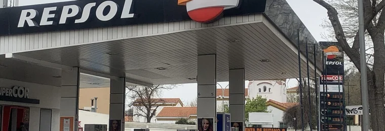 Repsol petrol station in Spain with fuel prices displayed on a roadside board.